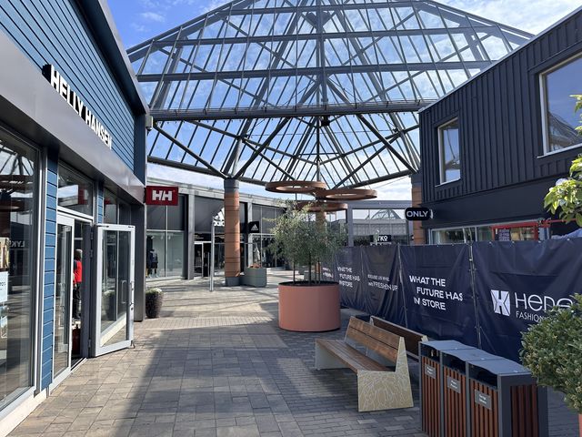 En av shoppinggatorna inne på Hede Fashion Outlet, med de ikoniska pyramidtaken i bakgrunden